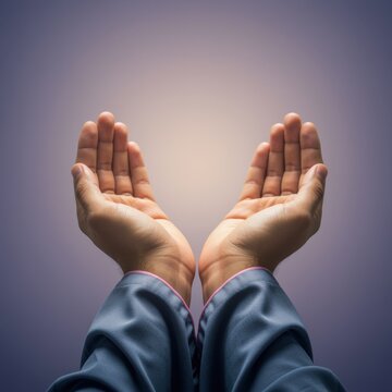 Two hands raised in prayer against a soft lilac background, human palms in supplication gesture for religious meditation app and spiritual health concept