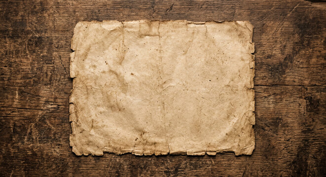 Weathered parchment paper on a distressed wooden desk with vast blank space