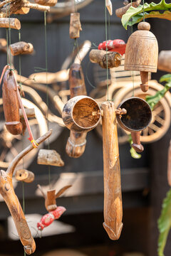 A unique collection of handcrafted wooden fertility symbols and charms hanging outdoors, featuring various phallic carvings and natural elements. A glimpse into traditional folk art.