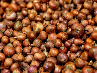 Obraz premium Fresh onions displayed for sale in a local market. The close-up view highlights natural texture, organic produce, and the vibrant atmosphere of a traditional marketplace.