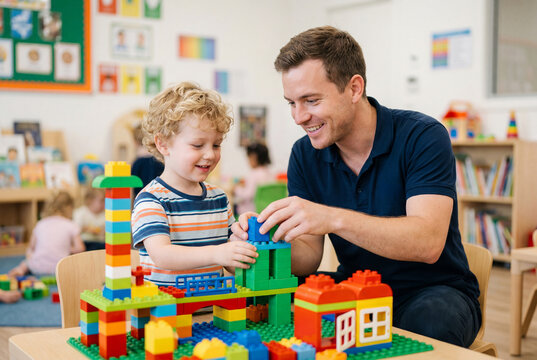 Male preschool teacher and young boy building with colorful plastic blocks