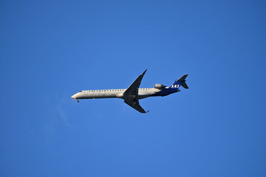 SAS Passenger Airplane Approaching for Landing Against Blue Sky, Aviation Editorial