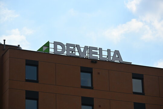 Develia Real Estate Developer Logo on Top of Modern Building, Corporate Branding Editorial