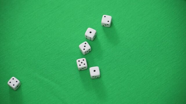 White dice rolling on green felt surface capturing motion chance and gambling concept