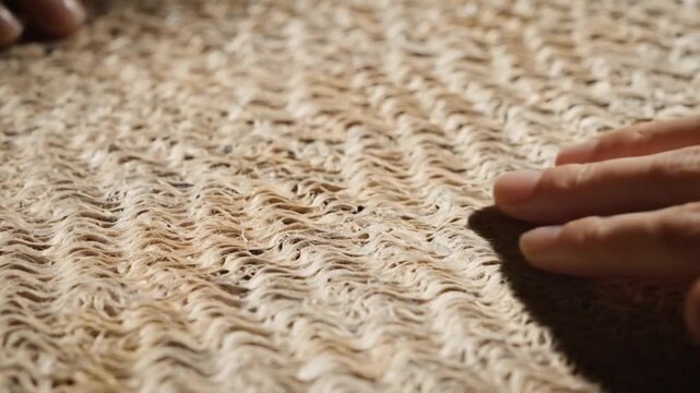 Woven jute rug texture, natural fiber close-up, beige woven mat, hand touching surface