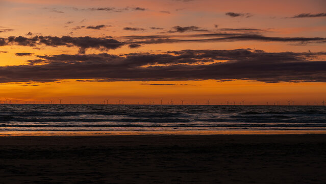 Colorful sunset with distant wind turbines