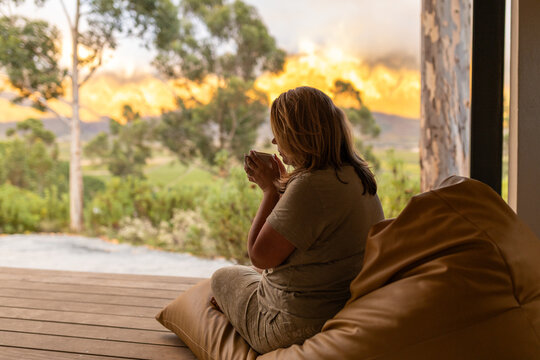 Women drinking coffee and admiring an outdoor view at sunrise