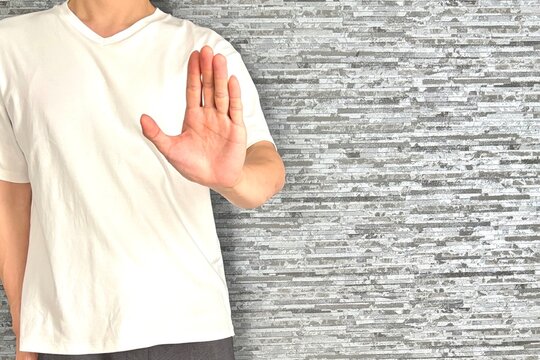 手を上げてストップをかける男性(顔無し)