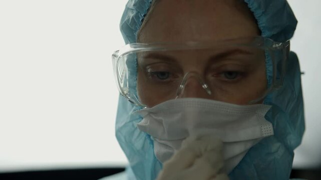 Scientist Wearing Protective Goggles and Face Mask In Laboratory.  Researcher Working In Biohazard Suit During Pandemic Research