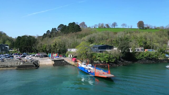Fowey, Cornwall, England: DRONE VIEWS: A static view of cars and vans disembarking the vehicle ferry at Fowey; the ferry runs from Bodinnick. A passenger ferry links Polruan with Fowey.