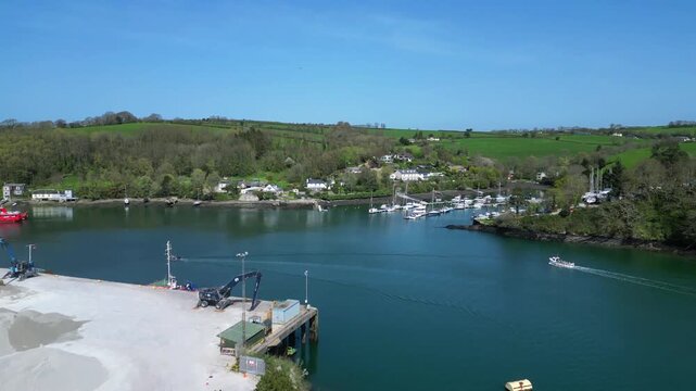 Fowey, Cornwall, England: DRONE VIEWS: Fowey Harbour on the River Fowey; a dock loader prepares a pile of china clay opposite Penmarlam marina. The clay arrives from St Austell and is exported abroad.
