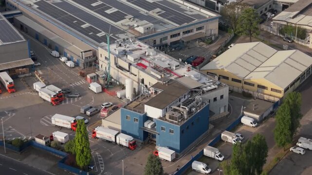 Industrial Facility Aerial View: An expansive aerial perspective showcases a bustling industrial complex with multiple buildings, warehouses, and delivery trucks.