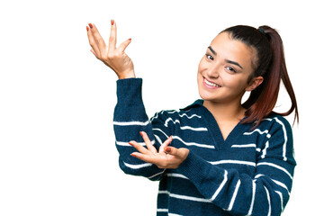 Naklejka premium Young beauty woman over isolated chroma key background extending hands to the side for inviting to come