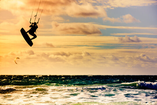 Kite surfer riding waves. Kiteboarding sport.