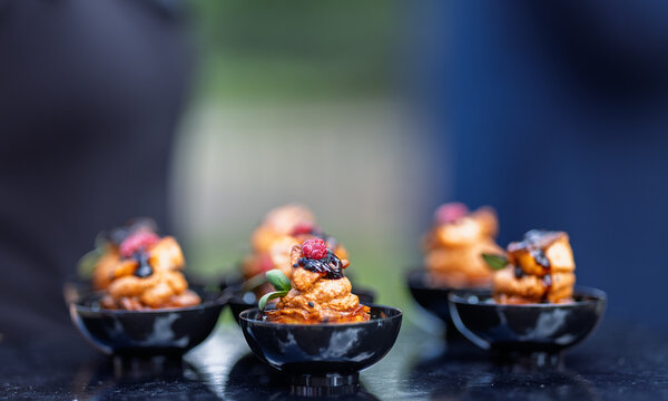 Gourmet Bite Sized Canapes With Berries and Glaze Served in Black Bowls for Cocktail Party