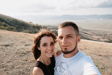 Obraz premium A selfie is a portrait of a young couple in love against the backdrop of a mountainous area. The concept of tourism, shared recreation