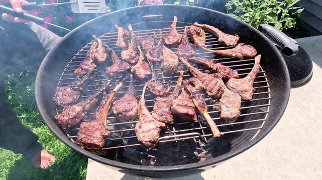 Lamb ribs are grilled over hot coals, the meat is turned with a spatula