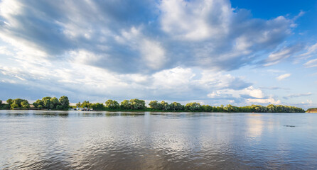 Obraz premium Blue sky holds wispy clouds above calm lake waters