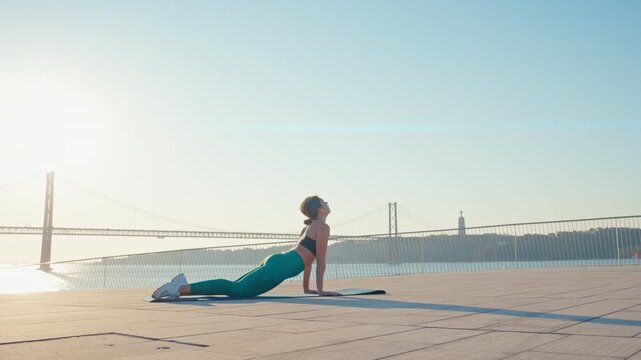 Woman practicing yoga outdoors doing upward facing dog pose