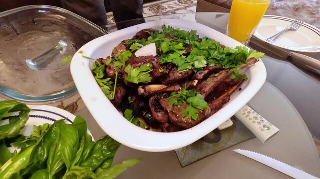 Lamb ribs are grilled over hot coals, the meat is turned with a spatula