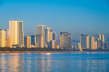 Obraz premium Panorama of waterfront with skyscrapers in Nha Trang in Vietnam at dawn in the morning. Beach with hotels in resort town in Asia