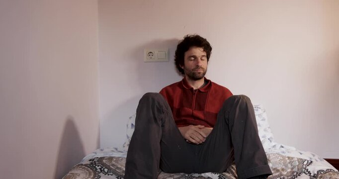 Bored lonely man getting up from bed