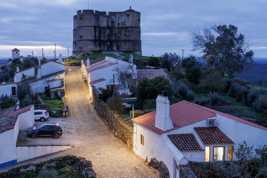 Evoramonte village castle and illuminated cobbled street at twilight, Alentejo, Portugal