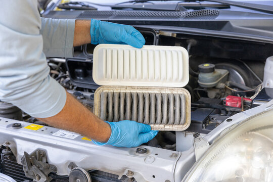 Replacing dirty and clean car engine air filter during vehicle maintenance service inspection