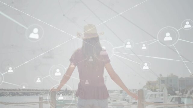 Female teen leaning railing while tech nodes starting at torso expanding over marina mapping links