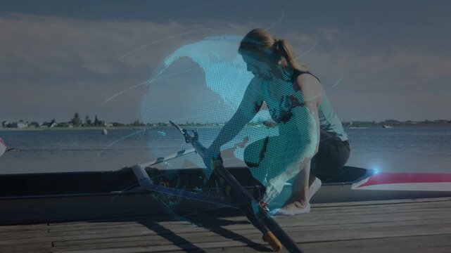 Rower crouching on dock starting sports prep, fixing oars and riggers while globe overlay centering