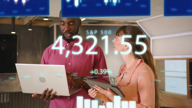Man with laptop, woman with tablet viewing S and P500 overlay appearing, pointing and confirming tra