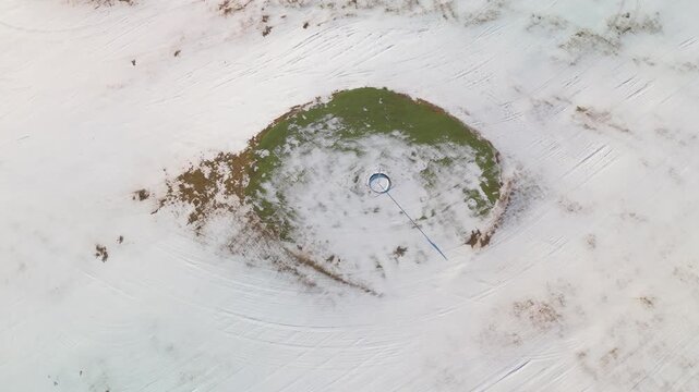 Aerial view of bus depot with turquoise buses parked in snowy industrial area