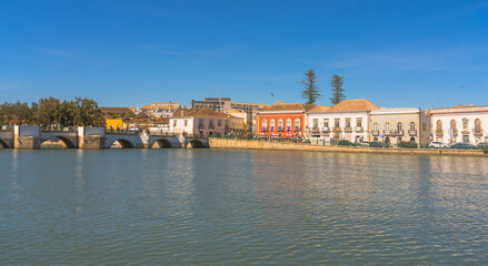 Obraz premium Colorful riverside buildings and bridge in Tavira Portugal