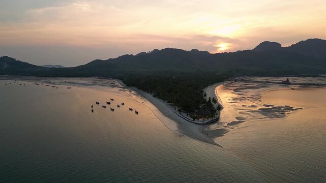 Koh Muk, Thailand: Aerial drone of the sunset over Koh Mook tropical island famous for its triangle beach in the Andaman sea near Trang in Thailand, with a backward and upward revealing motion