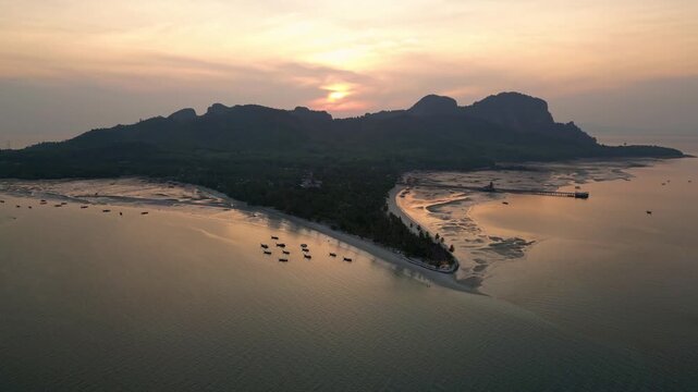 Koh Muk, Thailand: Aerial orbit drone of the sunset over Koh Mook tropical island famous for its triangle beach in the Andaman sea in Trang province in southern Thailand. 