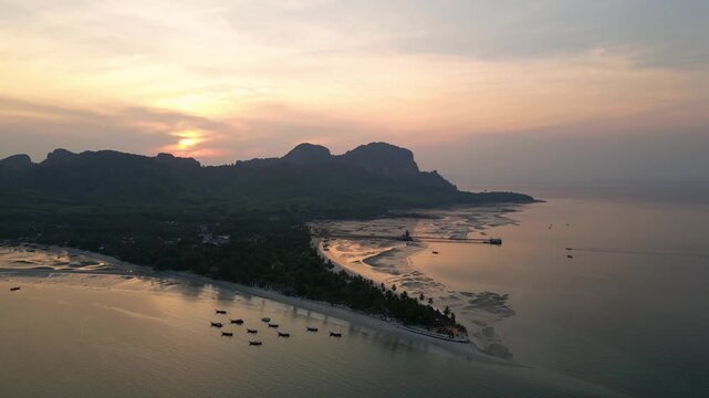 Koh Muk, Thailand: Aerial drone of the sunset over Koh Mook tropical island famous for its triangle beach in the Andaman sea  in southern Thailand. Shot with an orbit and forward motion