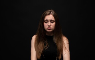 Naklejka premium Young woman dealing with sadness, grief, depression, and mental health issues, feeling emotional with closed eyes