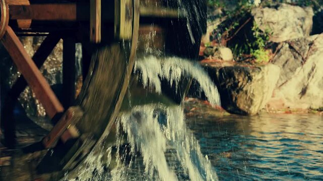 Spinning wooden waterwheel with splashing water sound 