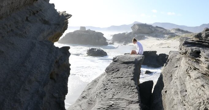 teenage girl overlooking beautiful rocky coastline, Sopies Klip, Hermanus, South Africa