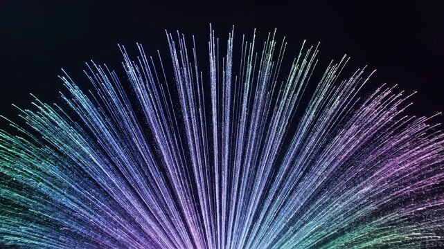Colorful light display with radiant beams expanding outward in a fan shape against a dark background, showcasing vibrant hues and dynamic visual effects