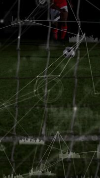 Vertical video: Player running to kick soccer ball into net, sports HUD tracing shot to score