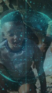 Vertical video: As child digging sand, adults lifting child to hold as teal tech orb covering hands