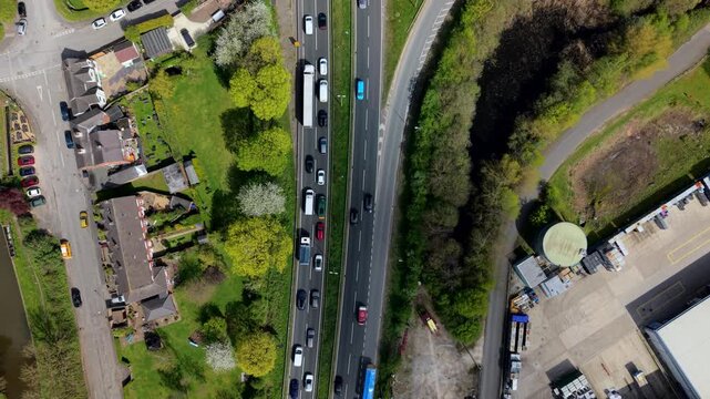 Top down aerial view of traffic driving through a busy industrial estate, showcasing commercial road transport and business logistics near Burton on Trent, UK.