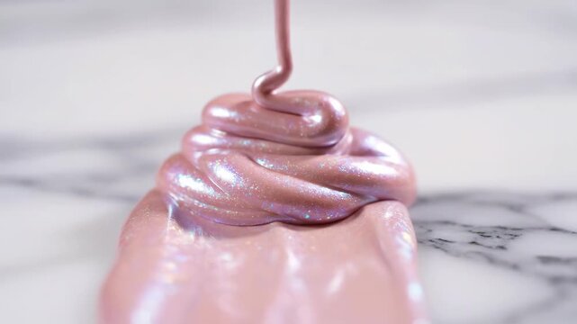 Pink glitter slime on a marble surface