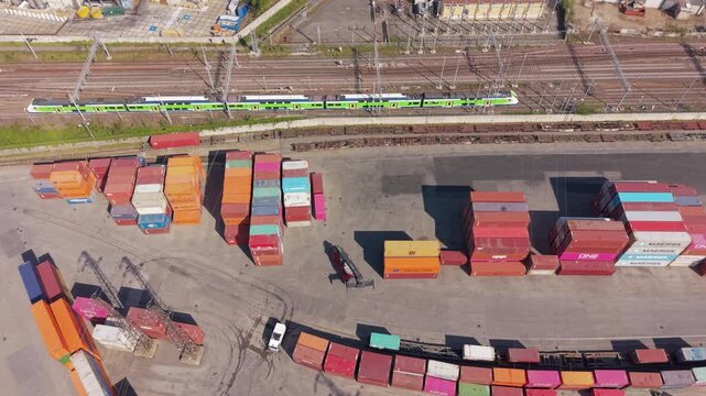 Cargo Containers and Train: Aerial view of a busy cargo port with stacks of colorful shipping containers and a train moving on tracks, highlighting global logistics and freight transportation.