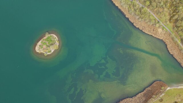 Aerial drone view of turquoise azure waters and a small central island at Albert Lake near Swadlincote UK