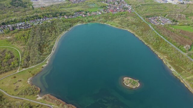 Aerial drone view of turquoise azure waters and a small central island at Albert Lake near Swadlincote UK