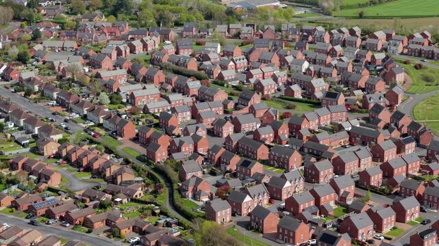 Aerial drone view of the historic town of Tutbury and close-up detail of a modern new build residential suburb development in Staffordshire, UK.