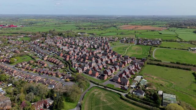 Aerial drone view of new build residential houses and the historic town of Tutbury in Staffordshire UK