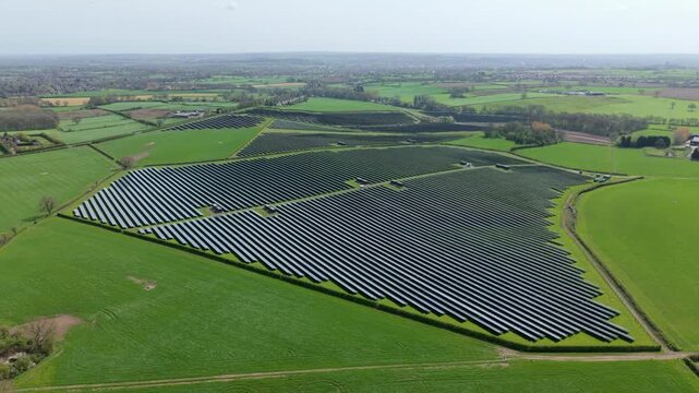 Top down aerial view of a geometric solar array and power inverter blocks, showcasing industrial symmetry and clean energy generation infrastructure in Tutbury, UK.